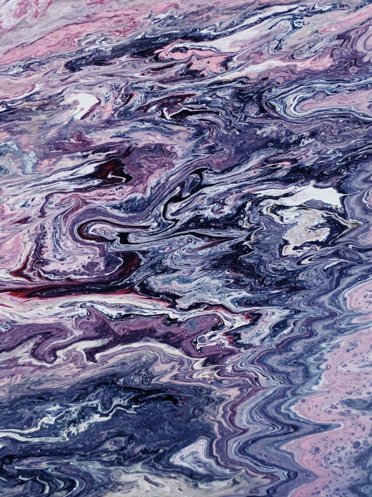 Vibrant abstract acrylic pour painting with swirling pink and blue textures.